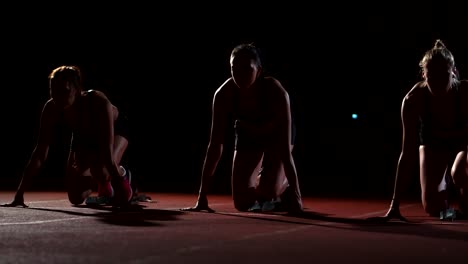 three-girls-athletes-at-the-start-preparing-for-the-race-and-start-on-the-treadmill