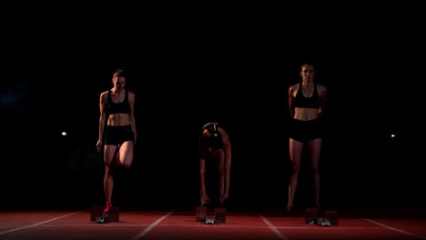 three-girls-athletes-at-the-start-preparing-for-the-race-and-start-on-the-treadmill