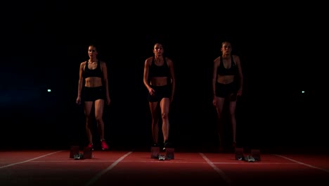 three-girls-athletes-at-the-start-preparing-for-the-race-and-start-on-the-treadmill