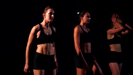 Three-girls-in-black-clothes-are-in-the-starting-pads-to-start-the-race-in-the-competition