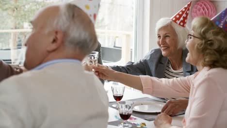 Gruppe-von-Senioren-Freunden-Toasten-auf-Geburtstagsparty