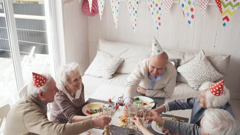 Draufsicht-der-Senioren-Freunde-Toasten-auf-Geburtstagsparty