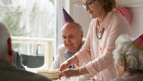 Senior-Lady-schneiden-süßen-Kuchen-zum-Geburtstag-Abendessen