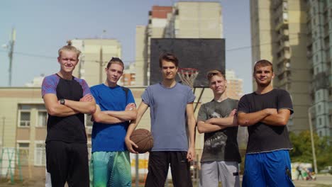 Smiling-streetball-players-with-basketball-on-court