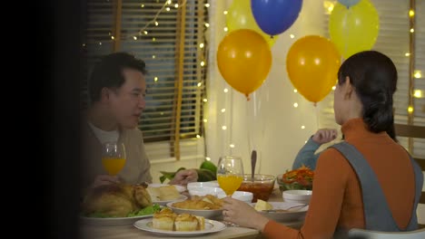 Family-toasting-at-christmas-dinner.-Happy-Asian-family-enjoying-christmas-dinner-together-at-home.