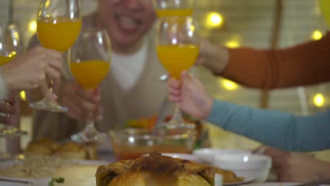 Familie-am-Weihnachtsessen-toasten.-Glückliche-asiatischen-Familie-Weihnachtsessen-zu-Hause-gemeinsam-genießen.