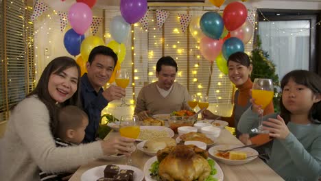 Familienglück-Asian-video-Anruf-tätigen-und-Weihnachtsessen-zu-Hause-gemeinsam-genießen.