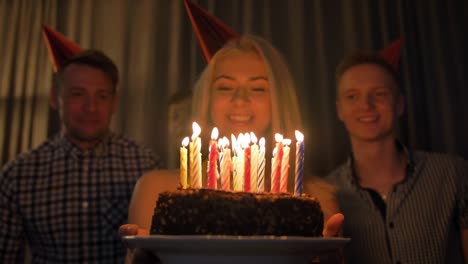 Beautiful-woman-shares-birthday-celebration-with-friends-gathered-blowing-out-candles-on-cake