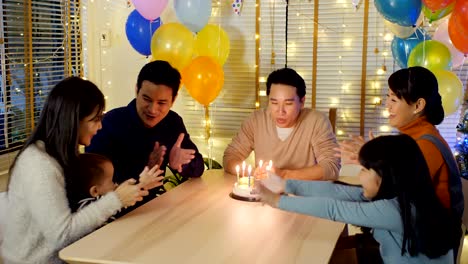 Asian-man-blows-out-candles-on-birthday-cake-at-party-with-happy-emotion.-People-with-party-and-celebration-concept.-4K-Resolution.