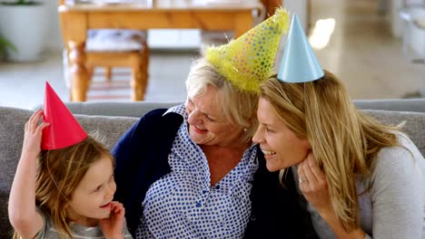 Generationsübergreifende-Familie-feiern-Geburtstag-auf-Sofa-4-k