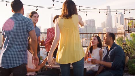 Freunde-versammelt-auf-Dachterrasse-zum-Geburtstag-mit-Skyline-der-Stadt-im-Hintergrund
