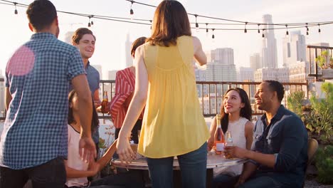 Amigos-se-reunieron-en-la-terraza-de-la-azotea-para-celebrar-el-cumpleaños-con-el-horizonte-de-la-ciudad-en-segundo-plano