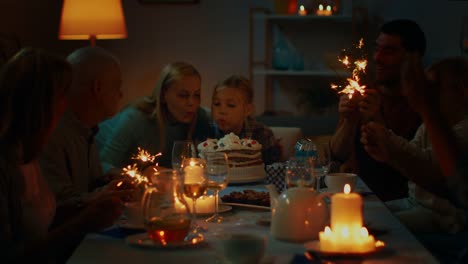 Birthday-Celebration-of-Cute-Little-Girl-at-the-Dinner-Table,-Surrounded-by-Family-and-Friends.-Daughter,-Mother-and-Father-Trying-Blowing-out-Candles-on-a-Cake.-Happy-Birthday-Celebration.