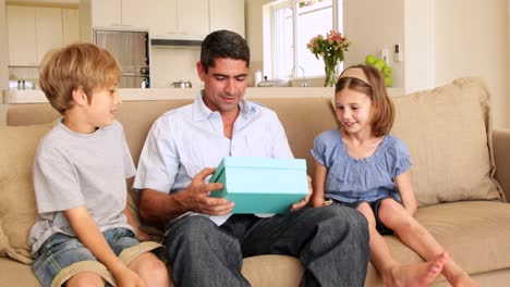 Cute-children-giving-their-father-presents-on-the-couch