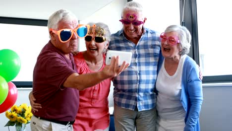 Tercera-edad-tomando-selfie-en-teléfono-móvil-durante-la-fiesta-de-cumpleaños