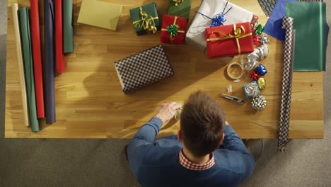 Top-View-of-Young-Man-Skillfully-Packing-Colorful-Gifts.-All-Happening-in-Fast-Motion.