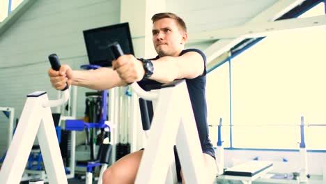 Guapo-hombre-deportivo-está-haciendo-ejercicio-en-el-gimnasio-y-el-gimnasio