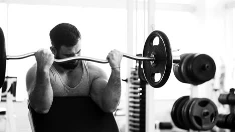 Guapo-hombre-deportivo-está-haciendo-ejercicio-en-el-gimnasio-y-el-gimnasio