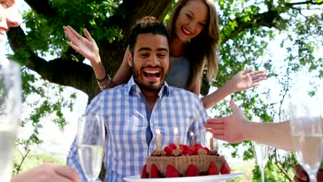 Friends-celebrating-mans-birthday-at-outdoor-restaurant