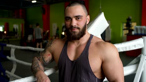 Handsome-sporty-man-smile-and-posing-into-camera-in-fitness-club