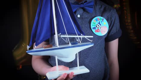 4K-Party-10-Birthday-Boy-Holding-Present-Toy-Boat