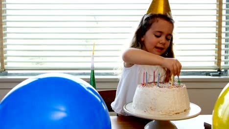 Girl-placing-candles-over-birthday-cake