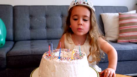 Soplar-velas-en-la-tarta-de-cumpleaños-niña