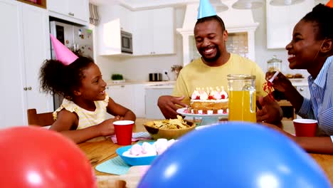 Family-celebrating-a-birthday-in-kitchen-at-home