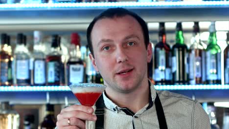 Friendly-bartender-looking-at-camera-and-inviting-you-to-his-bar