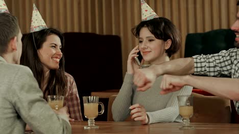 Young-girl-celebrating-birthday-in-cafe,-talking-on-cell-phone