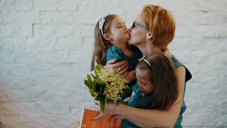 encantadoras-hijas-dan-a-mamá-un-regalo-y-flores