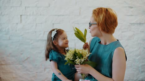 Mother-and-little-daughter-smell-beautiful-flowers