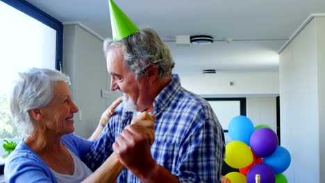 Senior-pareja-con-sombreros-de-fiesta-bailando-en-el-cumpleaños-del-partido-4k