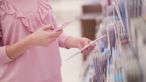 Woman-photographing-greeting-card-through-smartphone-in-store