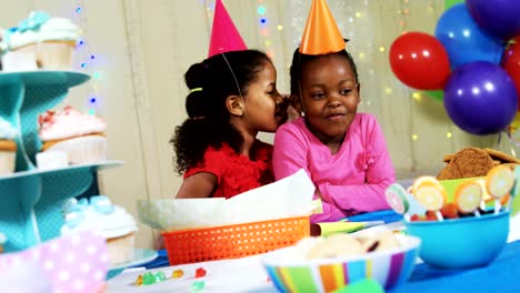 Girl-whispering-secret-to-her-friend-during-birthday-party-4k