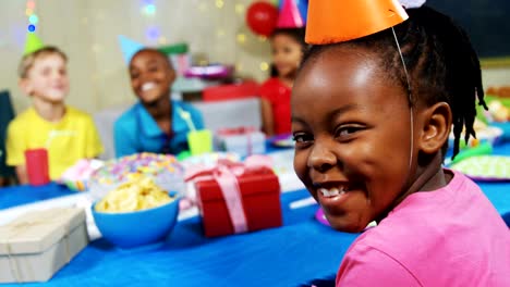 Retrato-de-niña-sonriente-sentado-con-amigos-en-la-mesa-durante-la-fiesta-de-cumpleaños-4k