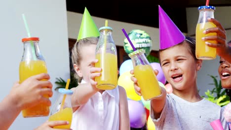 Niños-tostar-las-botellas-de-jugo-en-el-patio-trasero-de-casa-4k