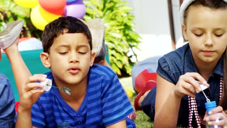 Amigos-felices-jugando-con-la-varita-de-la-burbuja-en-el-patio-trasero-4k