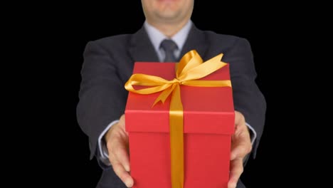 Un-hombre-en-un-traje-con-una-corbata-es-la-celebración-de-una-caja-de-regalo-roja.-Un-hombre-da-un-regalo.-Un-empresario-con-un-regalo-en-sus-manos.-Fondo-transparente-de-pantalla-verde-canal-alfa.-De-unfocus-al-foco.