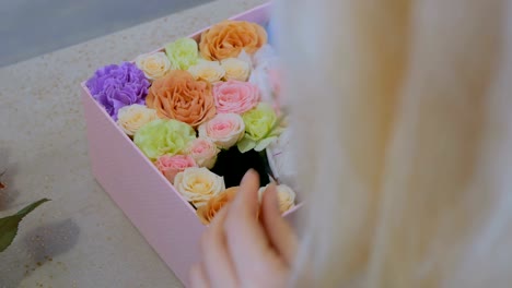 Professional-florist-making-gift-box-with-flowers-at-flower-store
