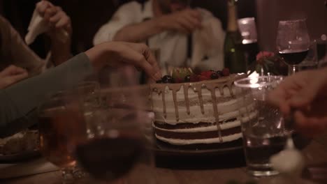 People-eating-dessert-cake-with-fruit-at-countryside-dinner-party