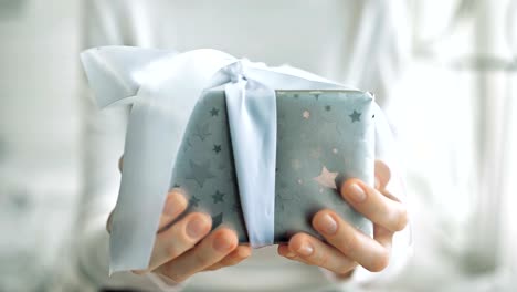 Young-woman-hands-holding-gift-box