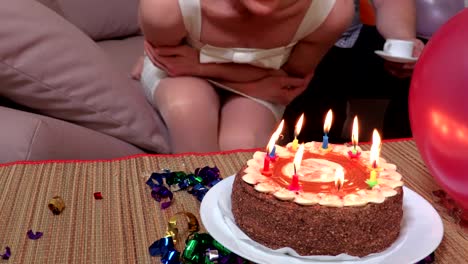 Woman-blows-candles-on-birthday-party-cake