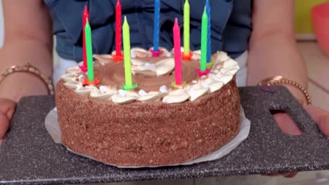 Woman-with-birthday-cake-at-home-in-kitchen