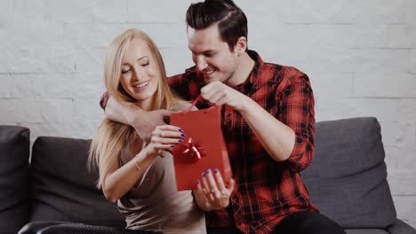 young-man-gives-a-gift-to-a-girl-on-the-couch