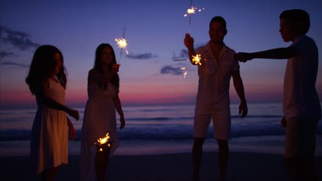 Español-familia-celebrando-cumpleaños-con-luces-de-Bengala-al-atardecer