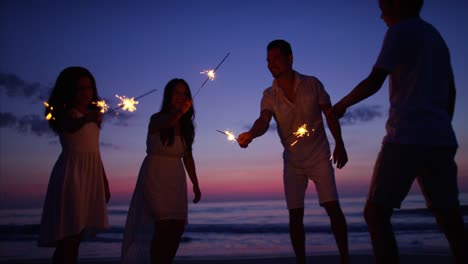 Hispanic-family-celebrating-birthday-with-sparklers-at-sunset