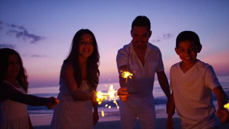 Cumpleaños-celebración-familiar-hispanico-con-luces-de-Bengala-en-la-playa