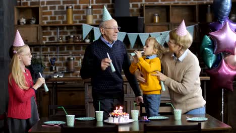 Glückliche-Familie-weht-Hörner-bei-Knaben-Geburtstags-party