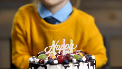 Torso-de-niño-niño-soplando-velas-sobre-el-pastel